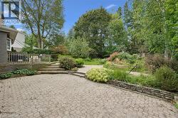Expansive paver patio with a raised wooden deck and steps - 