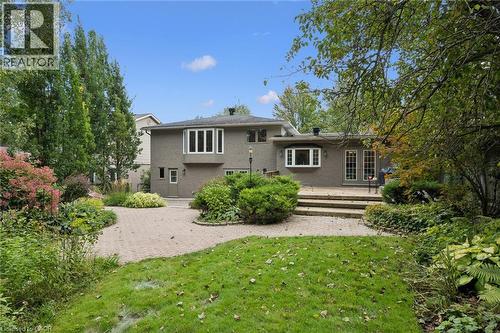 Exterior featuring a brick facade, multi-pane windows, a bay window, and double French doors opening to a hardscaped patio - 334 Coleridge Drive, Waterloo, ON 