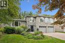 Stone exterior featuring multiple arched windows, a two-car garage, and a paver driveway - 334 Coleridge Drive, Waterloo, ON 