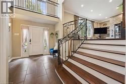 Two-story entryway featuring a decorative wrought iron staircase and a second-level balcony - 