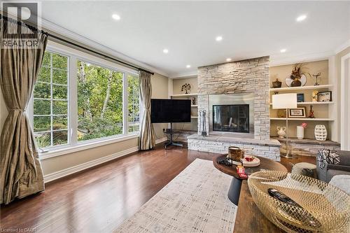 Expansive picture window, recessed ceiling lighting, wood-finish flooring, stone-clad fireplace, and built-in shelving - 334 Coleridge Drive, Waterloo, ON 