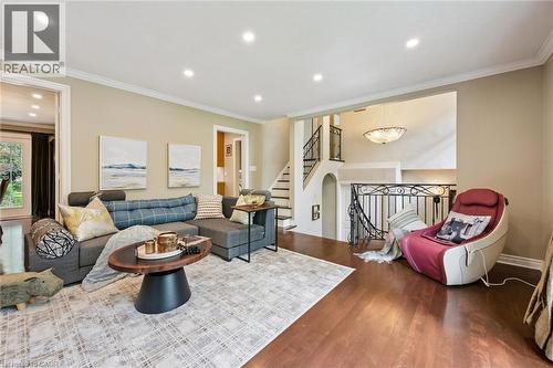 Wood-finish flooring throughout, recessed ceiling lighting, crown molding, and wrought iron stair railing with a decorative chandelier - 334 Coleridge Drive, Waterloo, ON 