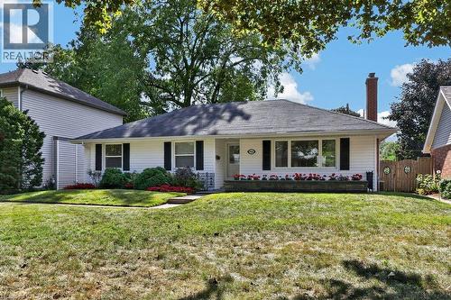 Ranch-style exterior with white siding, a dark shingle roof, and black window shutters - 948 Long Drive, Burlington, ON 