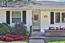 White siding exterior with dark shutters, concrete walkway, and a stone-faced planter box - 948 Long Drive, Burlington, ON 