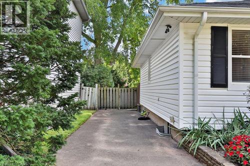 White siding exterior with black louvered shutters and a paved driveway - 948 Long Drive, Burlington, ON 