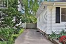 White siding exterior with black louvered shutters and a paved driveway - 948 Long Drive, Burlington, ON 