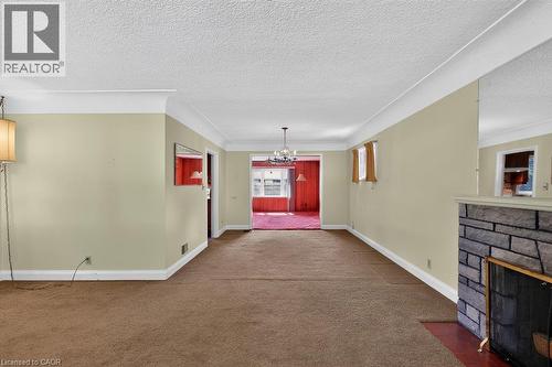 Spacious room with crown molding, textured ceilings, and a stone fireplace - 948 Long Drive, Burlington, ON 