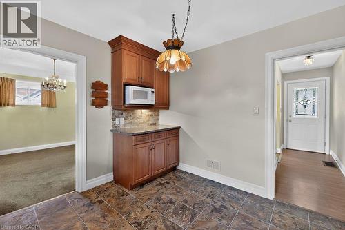 Built-in cabinetry with a stone countertop and tiled backsplash - 948 Long Drive, Burlington, ON 