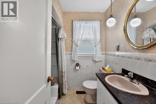 Bathroom featuring a vanity with a dark countertop, an oval basin, and a decorative mirror - 948 Long Drive, Burlington, ON 