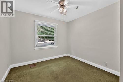 Ceiling fan fixture, window with horizontal blinds, neutral wall paint, and green carpet flooring - 948 Long Drive, Burlington, ON 