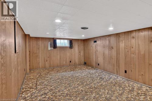 Finished basement featuring wood-paneled walls, carpeted flooring, recessed lighting, and a small window for natural light - 948 Long Drive, Burlington, ON 