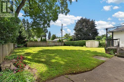 Expansive backyard featuring a lush lawn, concrete patio, and a wood privacy fence - 948 Long Drive, Burlington, ON 