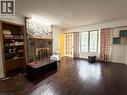 Stone-clad fireplace with a wood mantle, built-in shelving, wood-finish flooring, and French doors - 450 Bridge Street W, Waterloo, ON 