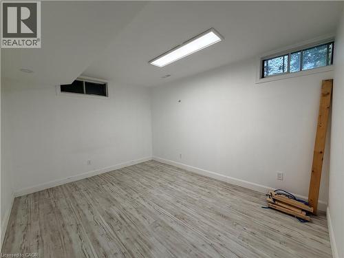 Recessed and surface-mounted lighting illuminate this room, featuring wood-finish flooring and multiple windows - 450 Bridge Street W, Waterloo, ON 
