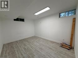 Recessed and surface-mounted lighting illuminate this room, featuring wood-finish flooring and multiple windows - 