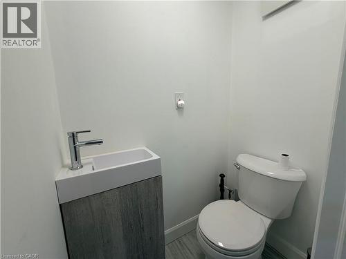 Modern vanity with an integrated basin, chrome faucet, and wood-finish cabinetry - 450 Bridge Street W, Waterloo, ON 