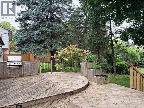 Multi-level wood deck featuring built-in planters and an integrated outdoor grilling station - 450 Bridge Street W, Waterloo, ON 