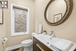 Vanity with integrated sink, chrome faucet, and a large oval mirror with an ornate frame - 