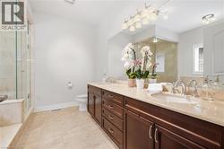 Double vanity with integrated sinks, rich wood-finish cabinetry, and polished chrome fixtures - 