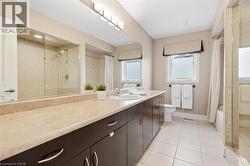 Double vanity with integrated sinks, dark wood-finish cabinetry, and a light-toned countertop - 