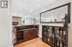 Custom built-in bar with wood-finish cabinetry, integrated wine storage, and a built-in sink - 