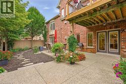 Brick exterior featuring a ground-level patio, double glass-paneled doors, and a wood-slatted deck overhead - 
