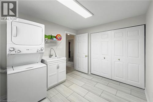 Light-toned tile flooring, utility sink with base cabinet, and built-in storage closets - 36 Buckingham Drive, Hamilton, ON 
