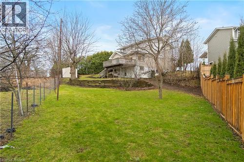 Expansive backyard featuring a manicured lawn, a wooden fence, and mature trees - 36 Buckingham Drive, Hamilton, ON 