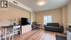 Wood-finish flooring, recessed lighting, neutral wall tones, and a window with blinds - 