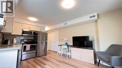 Kitchen with light-toned cabinetry and stainless steel appliances - 