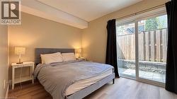 Wood-finish flooring, sliding glass door, private patio with paver stones, and a wood fence - 
