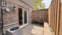 Brick exterior with stone accents, paver patio, wood privacy fencing, and exterior lighting fixture - 