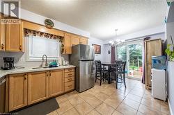 Kitchen featuring natural wood-finish cabinetry, light-toned countertops, and stainless steel appliances - 