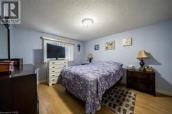Wood-finish flooring, a window with blinds, and light blue wall paint - 