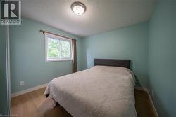 Sloped ceiling with flush mount lighting, wood-finish flooring, and a sliding window - 