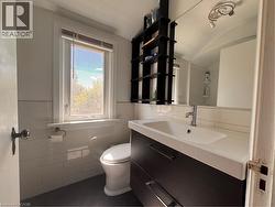 White subway tile wainscoting, a single vanity with integrated sink, and a wall-mounted mirror - 