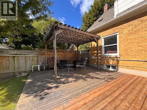 Expansive wood deck with a built-in pergola, privacy fencing, and a red brick exterior - 225 Bridgeport Road E, Waterloo, ON 