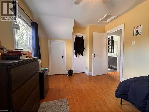 Hardwood flooring throughout, multiple built-in closets, window with blinds, and ceiling-mounted light fixture - 225 Bridgeport Road E, Waterloo, ON 