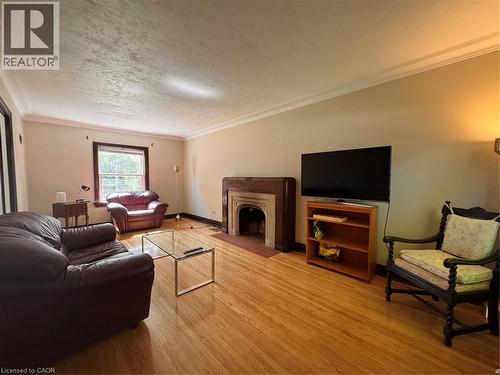 Hardwood flooring throughout, crown molding, and a wood-surround fireplace with a hearth - 225 Bridgeport Road E, Waterloo, ON 