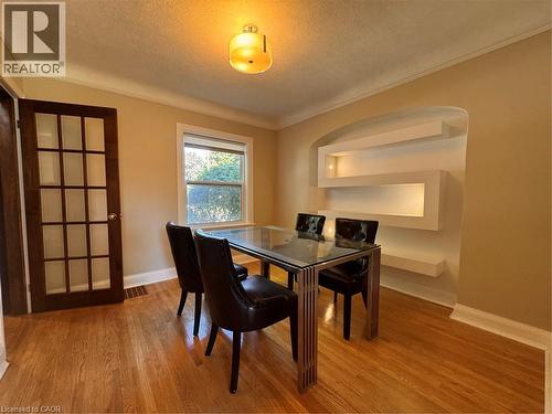 Hardwood flooring, built-in display shelving with accent lighting, window, full-light French door, and a flush-mount ceiling light fixture - 225 Bridgeport Road E, Waterloo, ON 