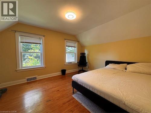 Hardwood flooring, two double-hung windows, sloped ceiling, and a flush-mount ceiling light fixture - 225 Bridgeport Road E, Waterloo, ON 