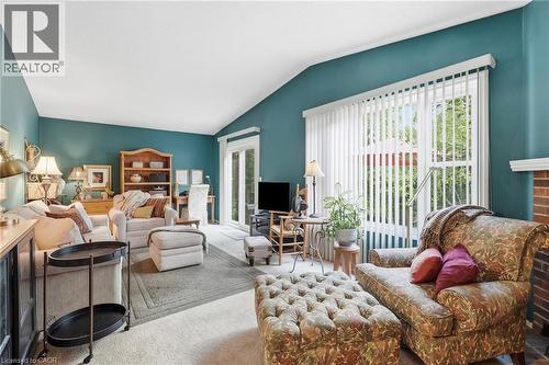 Vaulted ceiling, fireplace, vertical window blinds, and sliding glass door - 89 Brigade Drive, Hamilton, ON 