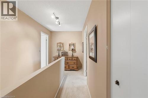 Hallway with warm neutral wall tones, track lighting, and white trim - 89 Brigade Drive, Hamilton, ON 
