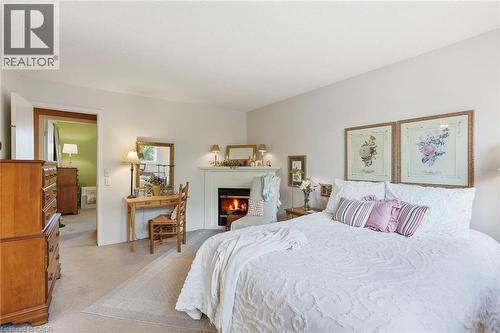 Spacious room featuring neutral carpeting, a built-in fireplace, and a white mantel - 89 Brigade Drive, Hamilton, ON 