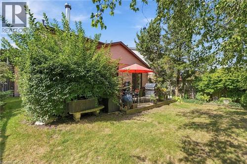 Lush green lawn with mature trees and a dedicated patio area and Napoleon Gas Barbecue - 89 Brigade Drive, Hamilton, ON 