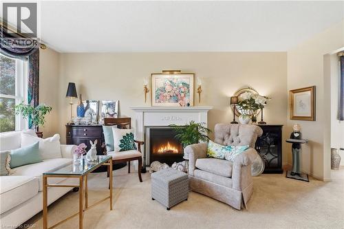 Fireplace with decorative mantle, neutral-toned walls, and carpet flooring - 89 Brigade Drive, Hamilton, ON 