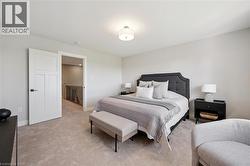 Soft neutral-toned carpet, white painted walls, white panel door with dark hardware, and a semi-flush mount ceiling light - 