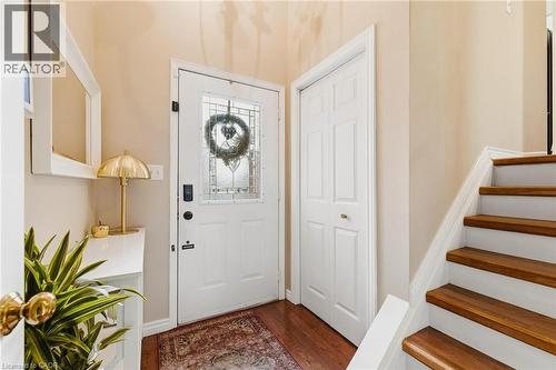 Entryway featuring a white paneled door with decorative glass, wood-finish flooring, a bi-fold closet door, and a staircase with wood treads and white risers - 245 Bishop Street S Unit# 31, Cambridge, ON 