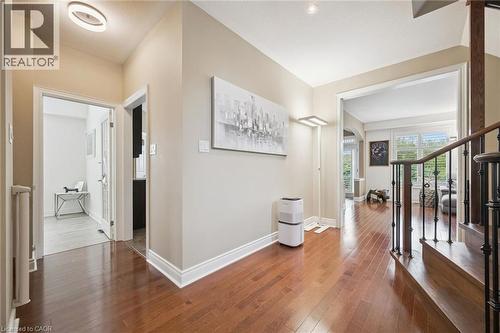 Wood-finish flooring, staircase with wrought iron balusters, recessed lighting, and crown molding - 517 Topper Woods Crescent, Kitchener, ON 