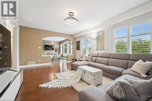Hardwood flooring, recessed lighting, arched doorway, window shutters, and a modern ceiling light fixture - 517 Topper Woods Crescent, Kitchener, ON 